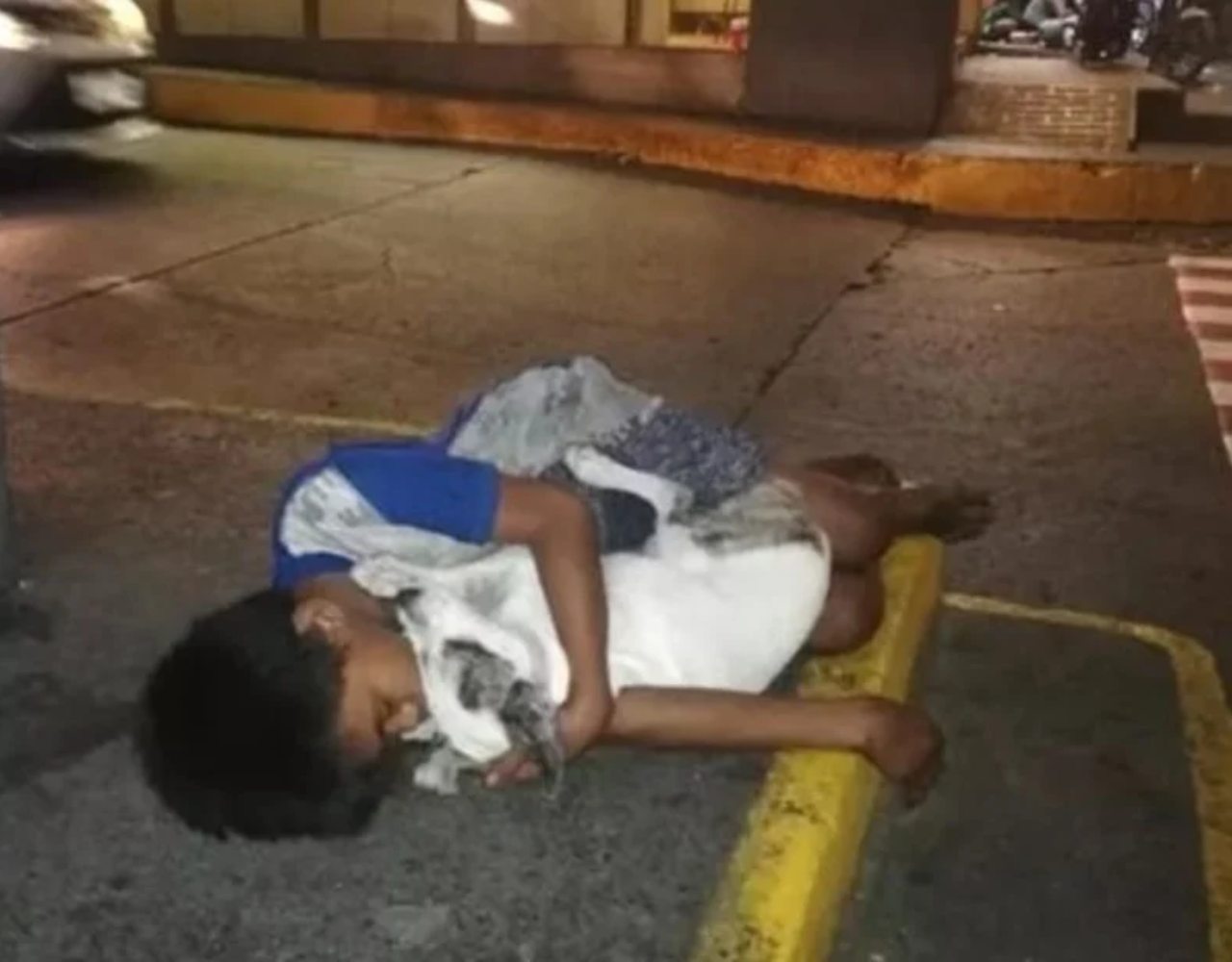 Captan a niño sin hogar abrazando a su perrito para soportar el frío de la calle